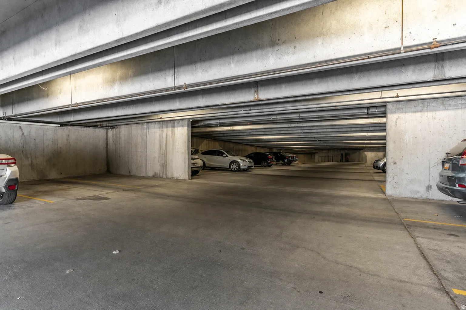 Underground parking garage featuring concrete construction and overhead lighting