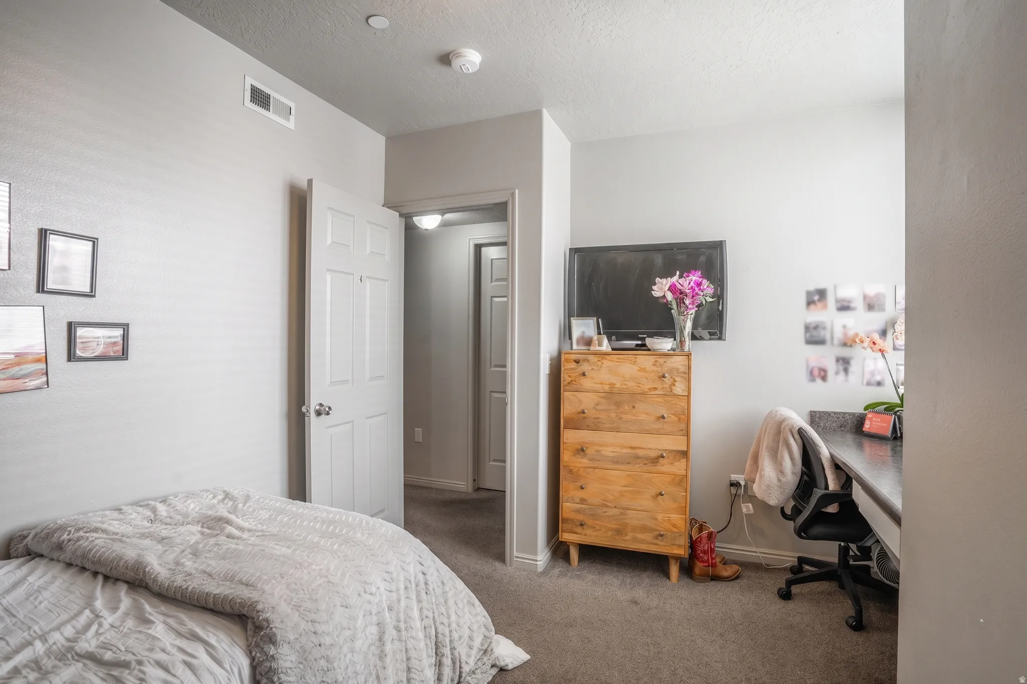 Carpeted room featuring light gray walls, a white ceiling, and a white six-panel door