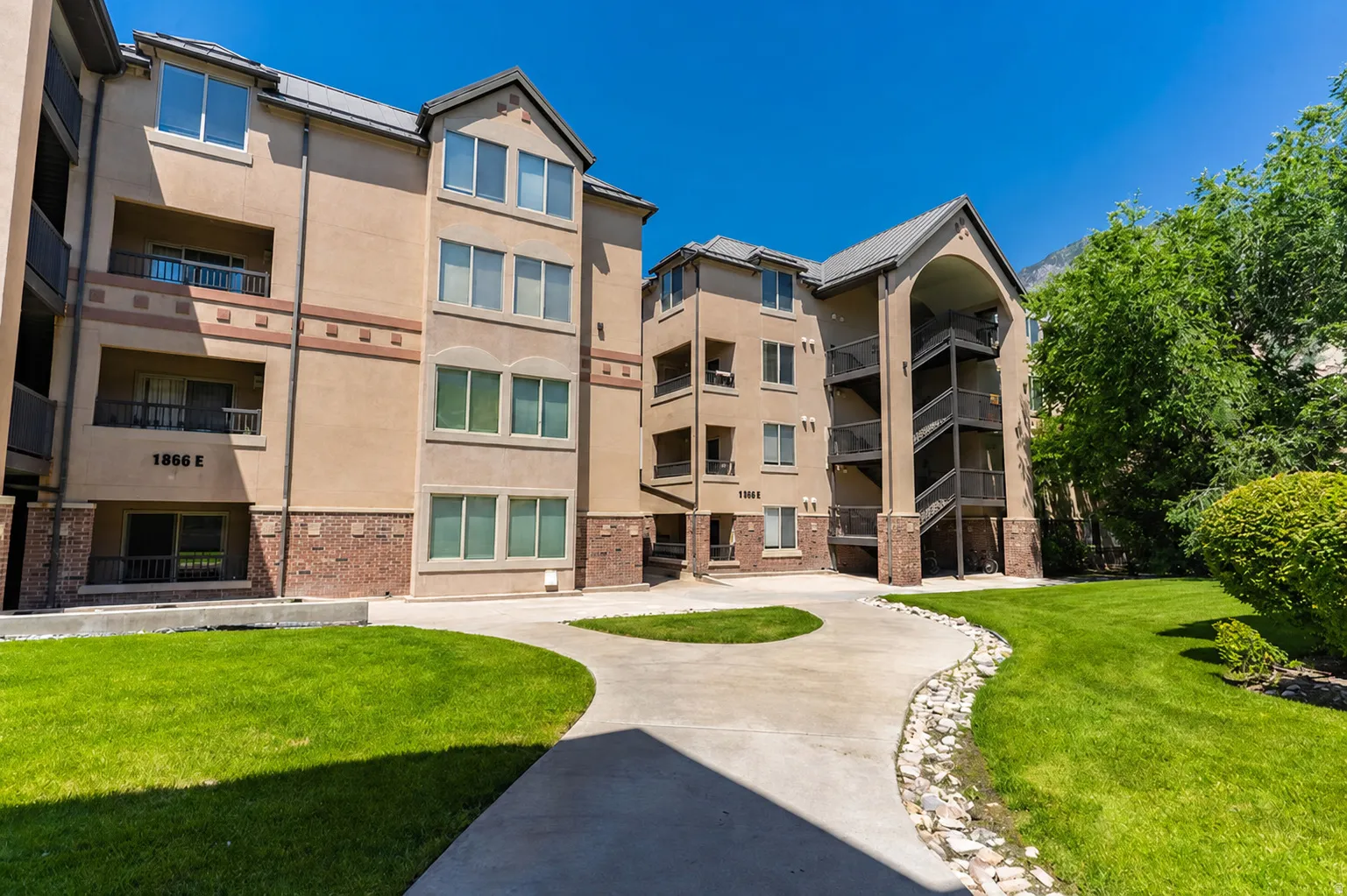 Multi-story stucco exterior with brick accents