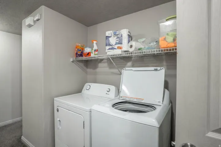 Dedicated laundry space featuring a top-load washer and front-load dryer
