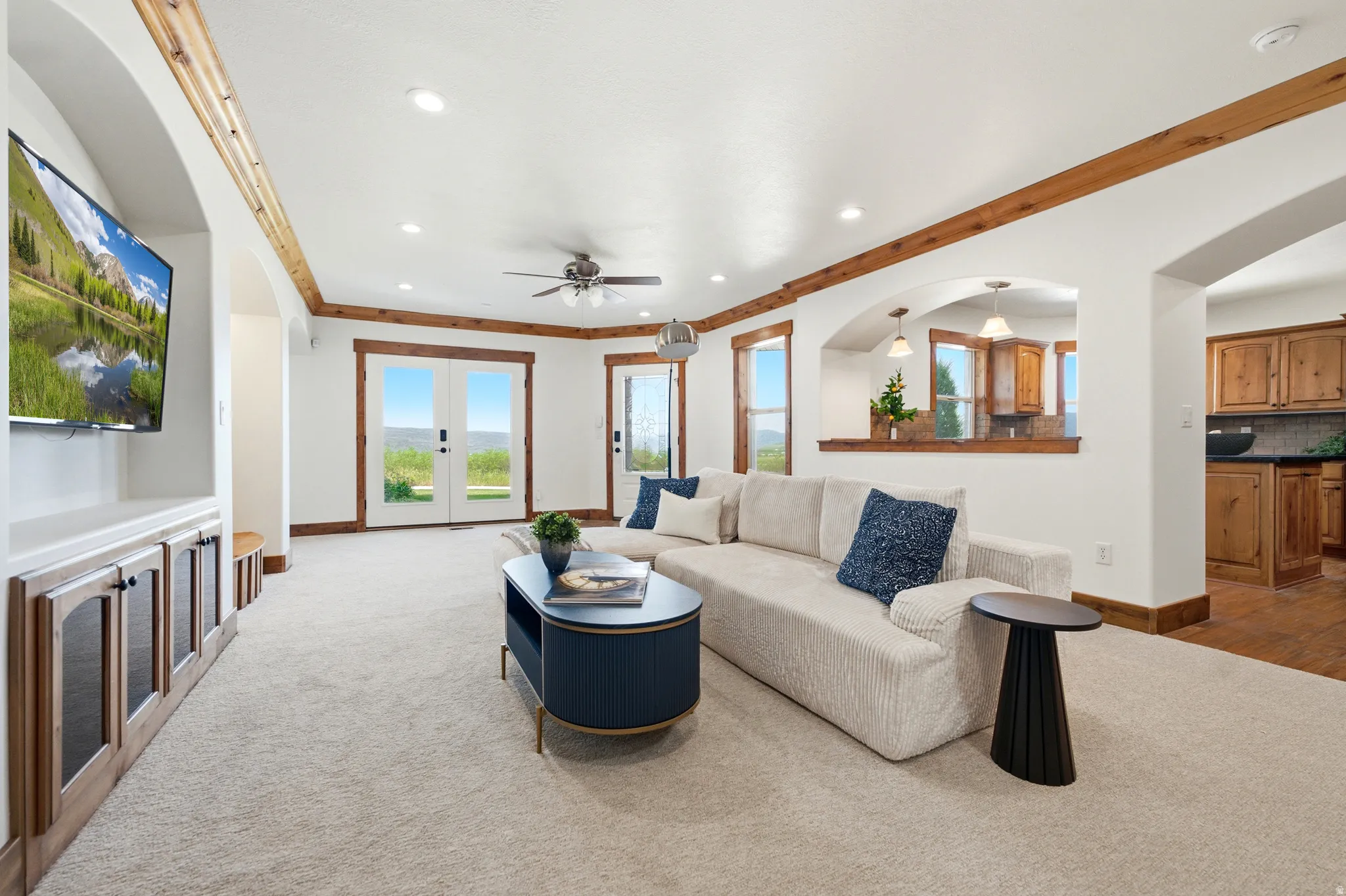 Spacious living area featuring light carpeting, wood-trim accents, and recessed lighting
