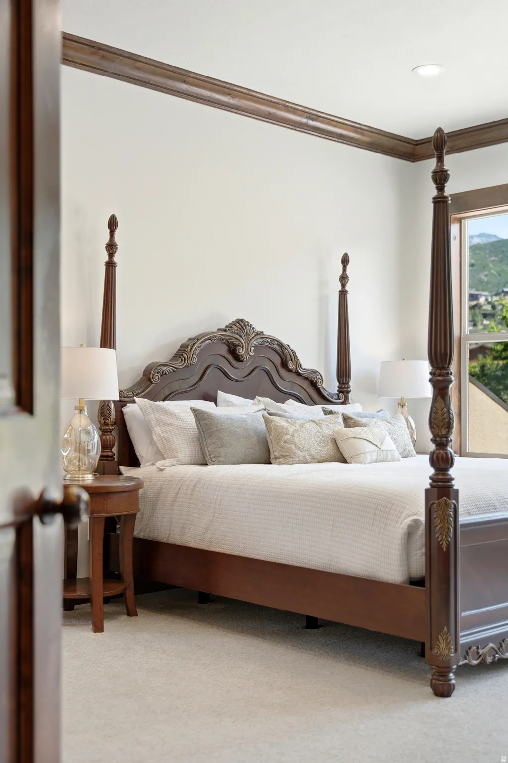Spacious room featuring light-colored carpeting, white wall paint, and dark wood crown molding