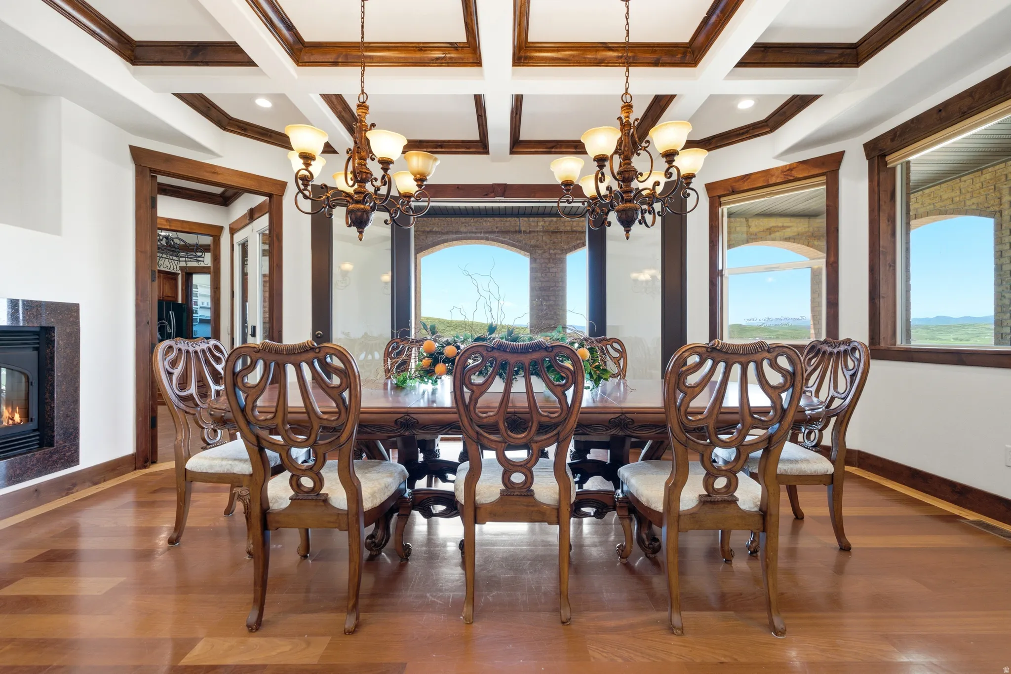 Dining area with wood-finish flooring, coffered ceilings, and a built-in fireplace