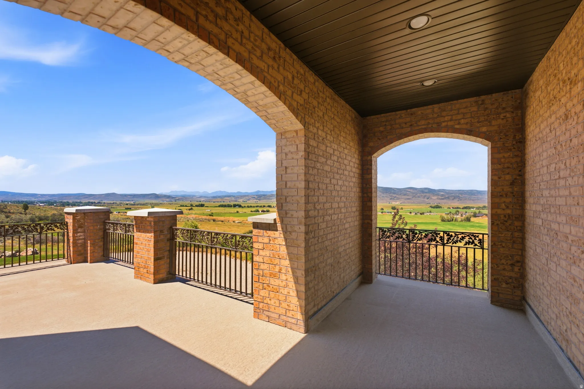 Expansive outdoor patio featuring brick construction and arched openings