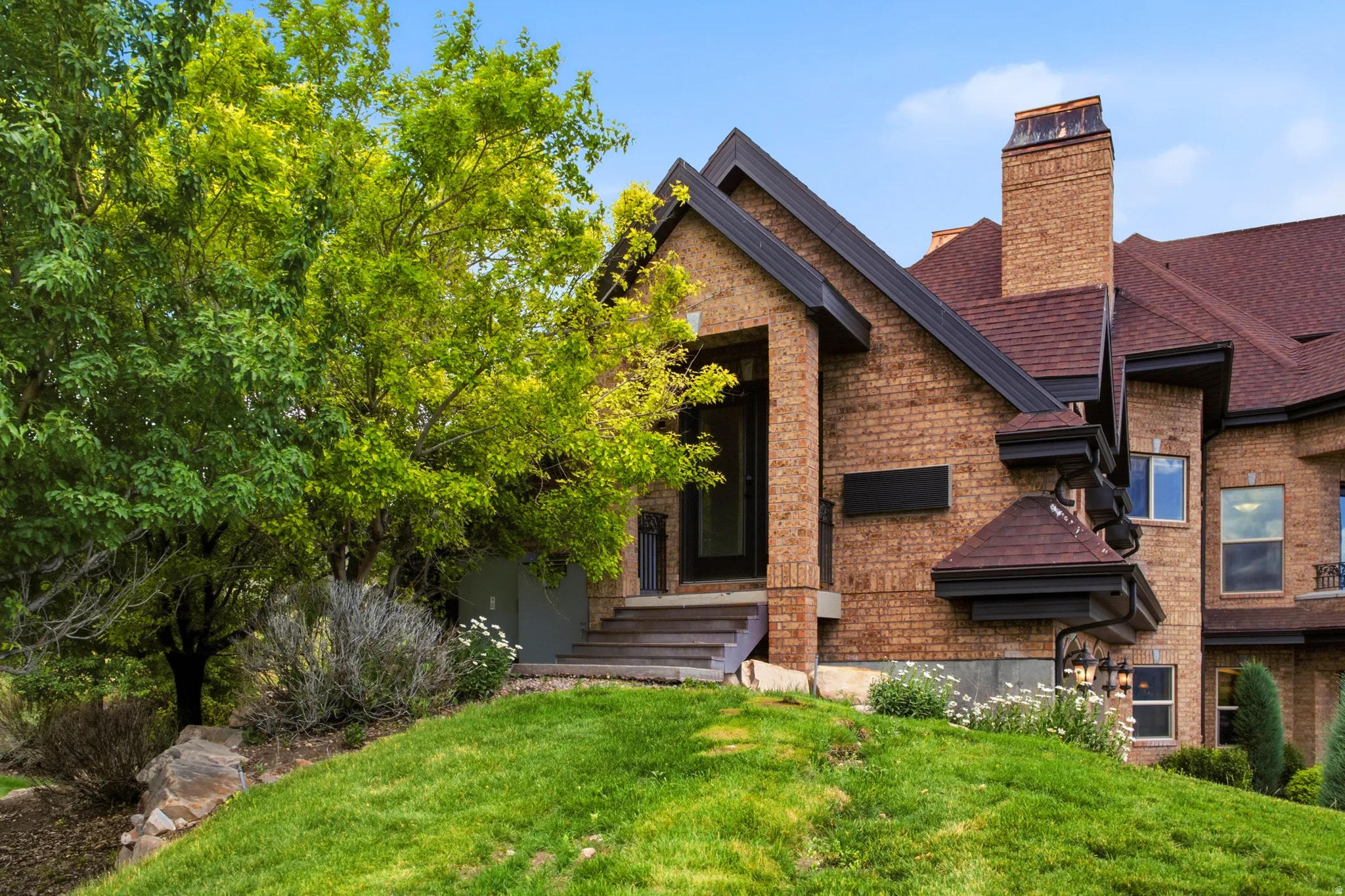 Brick exterior with a dark shingle roof and prominent brick chimney