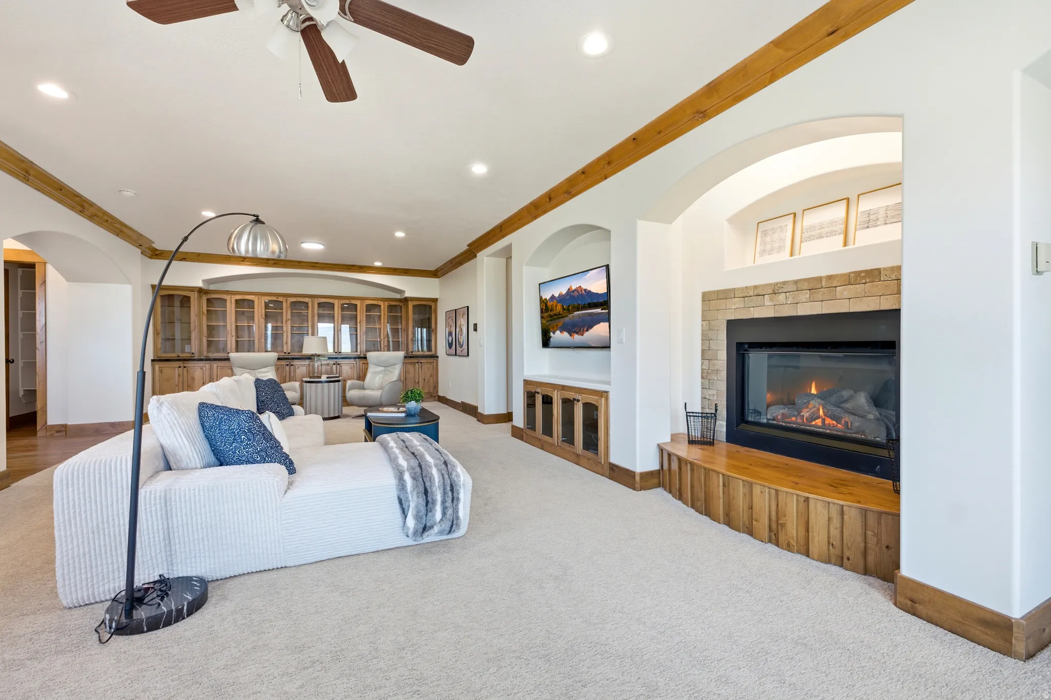Living area featuring a stone-surround fireplace with a wood hearth, recessed lighting, and a ceiling fan