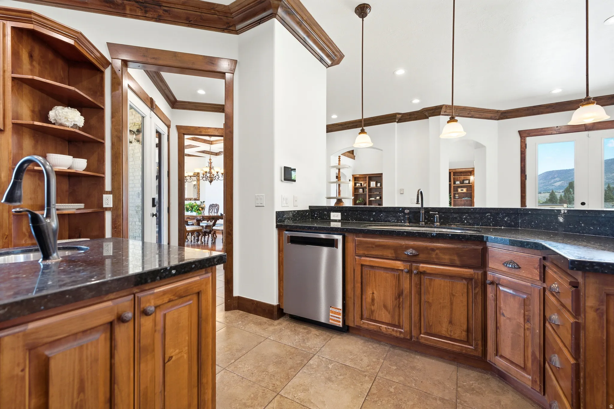 Kitchen featuring dark granite countertops, warm wood cabinetry, and stainless steel appliances