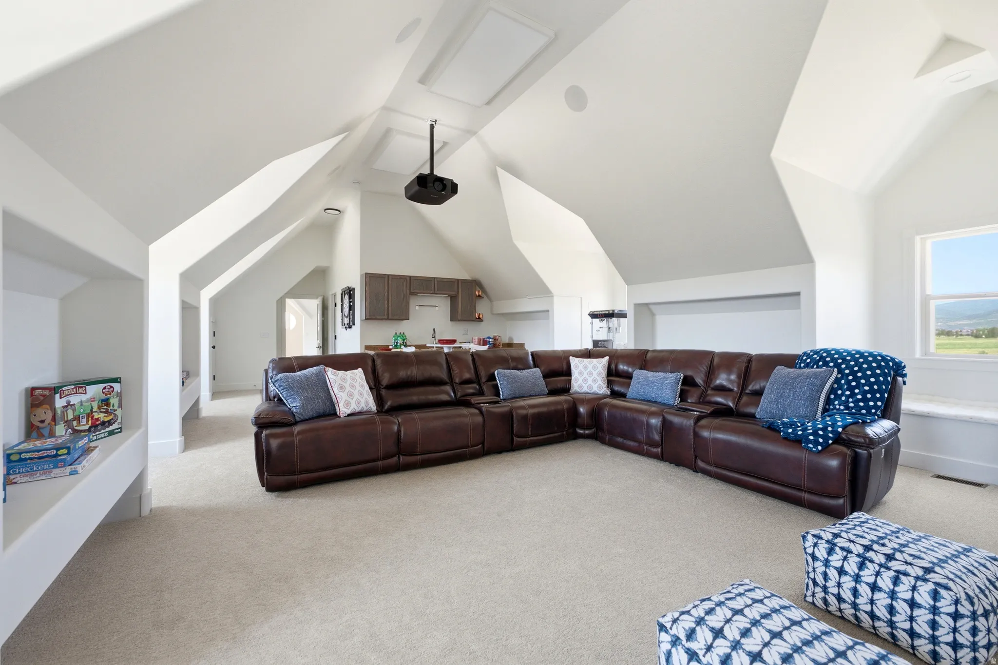 Spacious bonus room featuring vaulted ceilings, recessed lighting, wall-to-wall carpeting, a built-in wet bar with cabinetry, and a ceiling-mounted projector