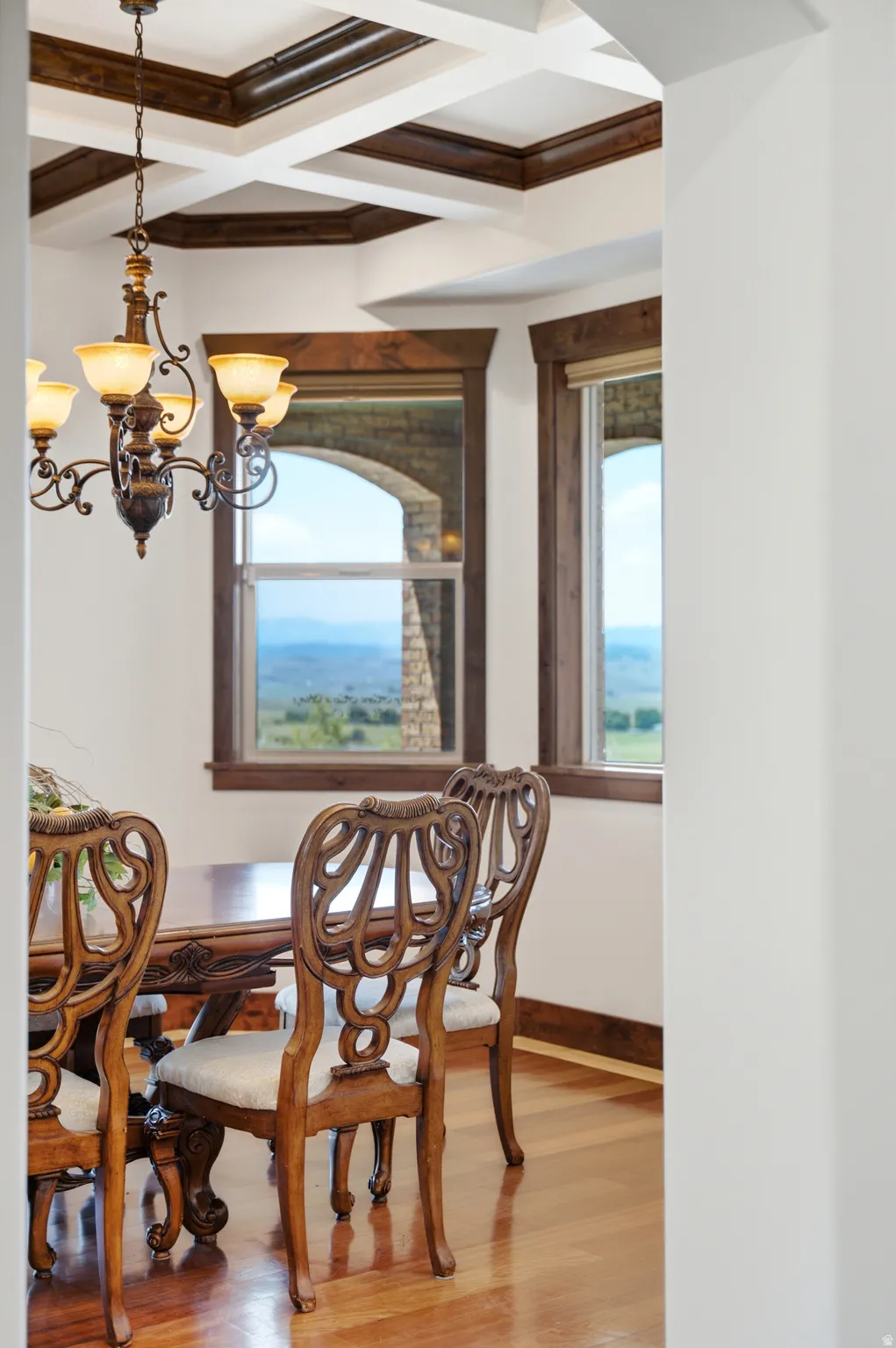 Coffered ceiling with dark wood accents, complemented by a decorative chandelier