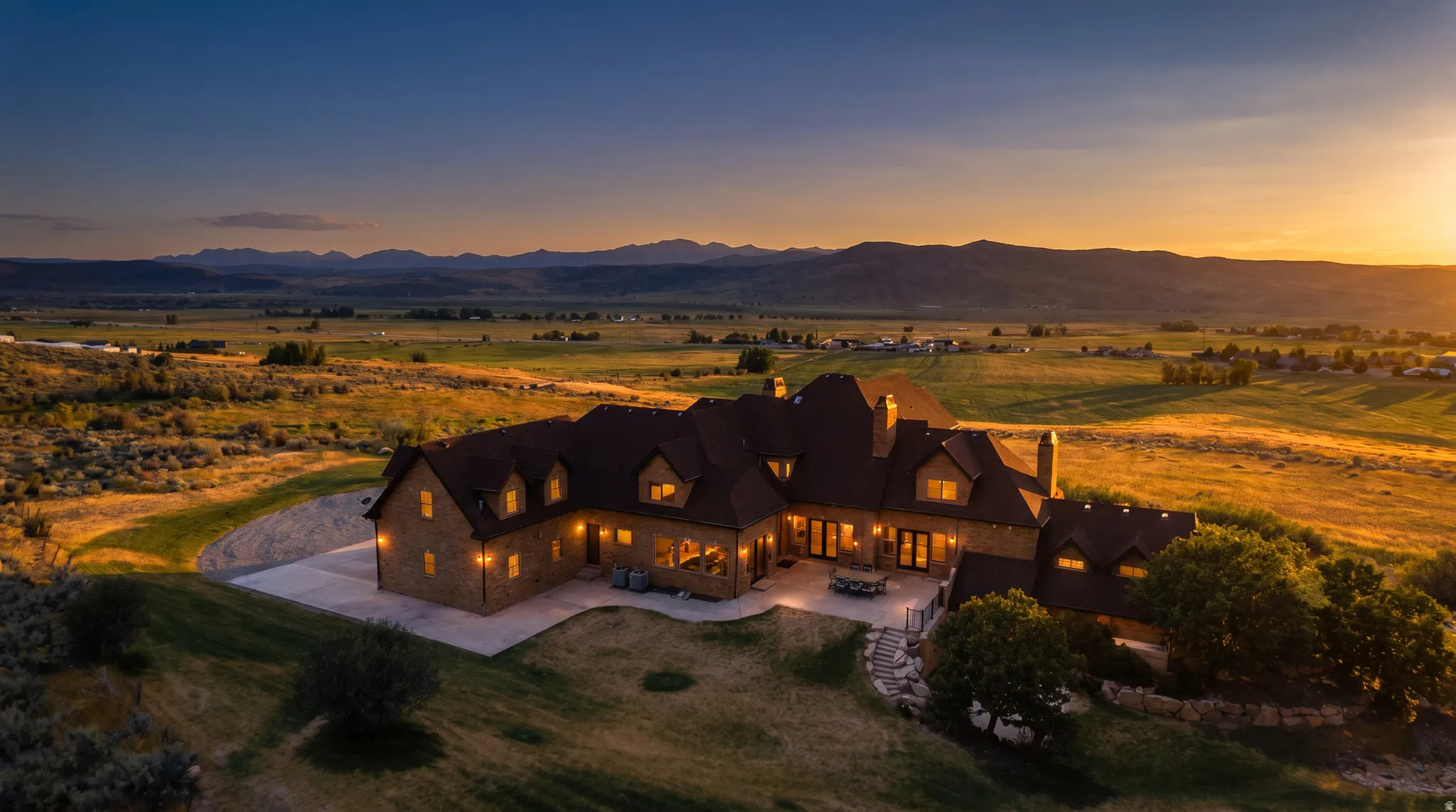 Expansive property featuring a stone exterior, multiple dormer windows, and a multi-level roofline
