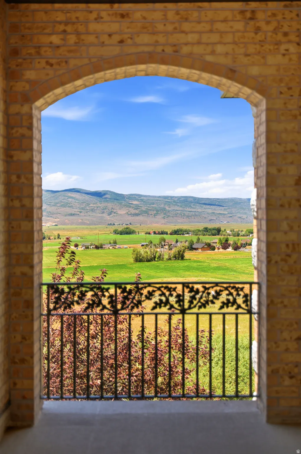 Arched brick entryway framing expansive rural scenery