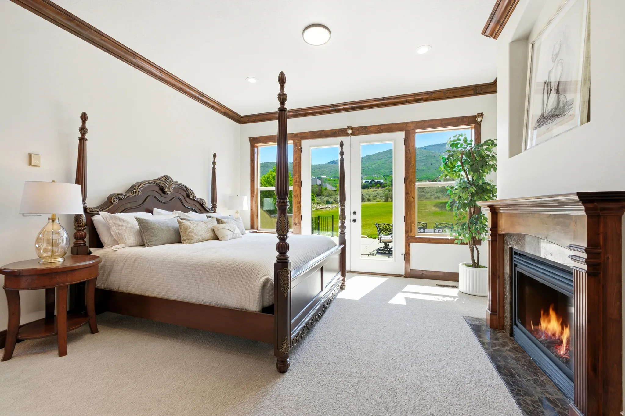 Bedroom featuring a wood-burning fireplace with a marble surround and wood mantel, light-toned carpet, and extensive wood trim
