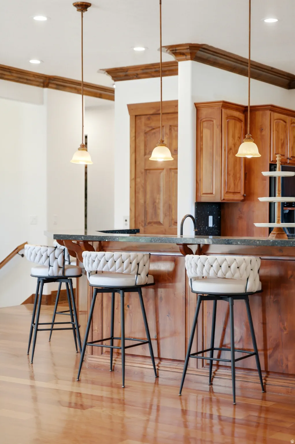 Kitchen island with a dark countertop and rich wood-finish cabinetry