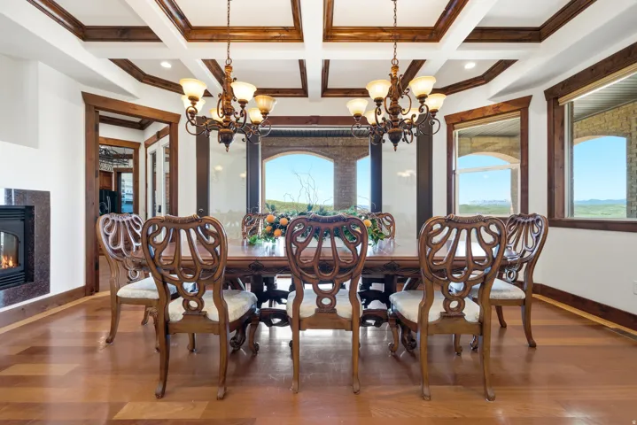 Dining area with wood-finish flooring, coffered ceilings, and a built-in fireplace