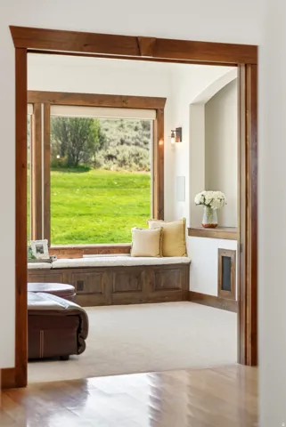 Built-in window seat with storage, framed by dark wood trim, offering expansive outdoor views