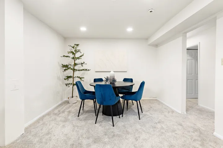 Spacious room featuring light-toned carpet flooring, recessed ceiling lighting, and crisp white walls