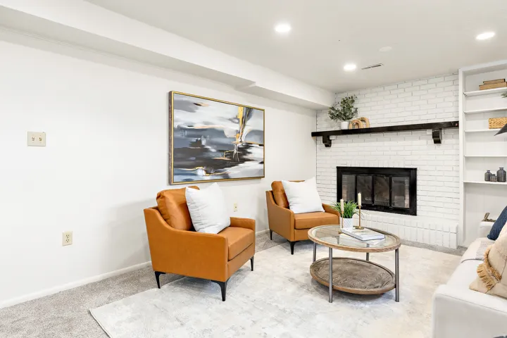 Bright living space featuring a white brick fireplace with a dark wood mantel