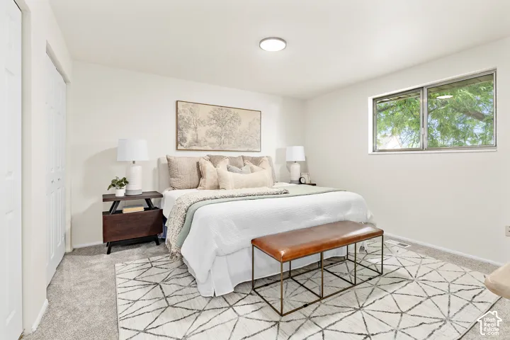 Neutral tone bedroom featuring white walls and light gray carpeting
