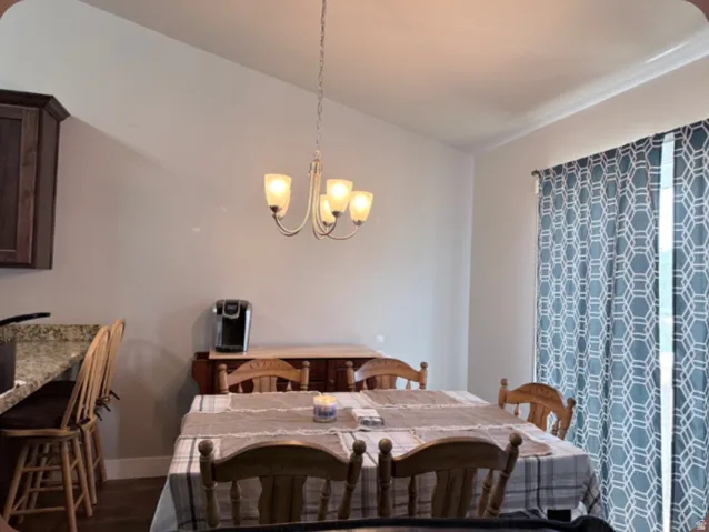 Ample dining area with vaulted ceiling and access to the back yard with a sliding glass door.