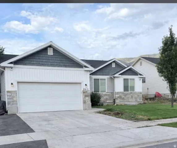 Modern exterior featuring mixed-material siding, stone accents, and a two-car garage