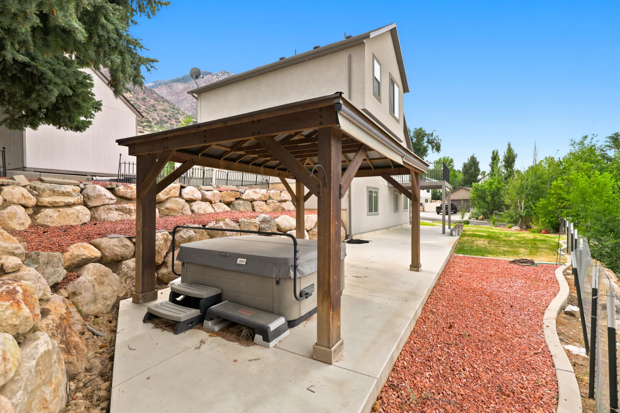 Covered patio area featuring a hot tub