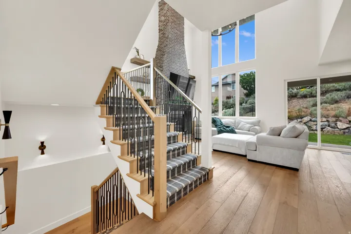 Open concept living area featuring a modern staircase with wood banister and wrought iron spindles