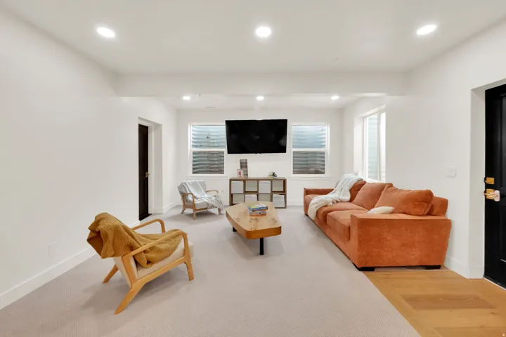 Recessed lighting illuminating a spacious room with light-colored carpeting