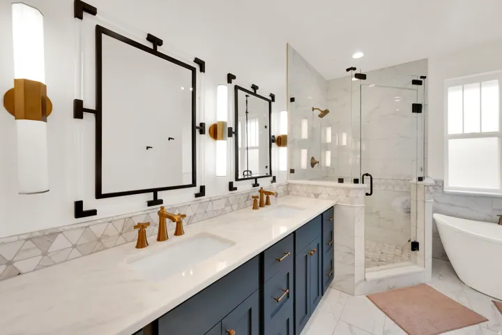 Dual vanity with white countertop, undermount sinks, and brass-finish fixtures