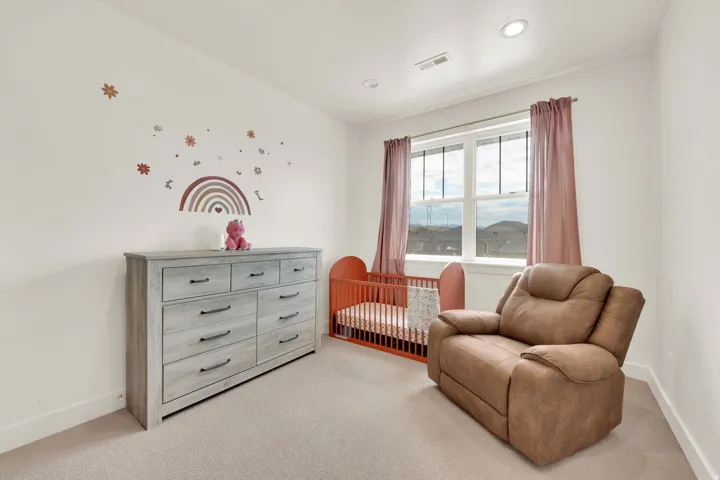 Bright room featuring light neutral carpeting and white walls
