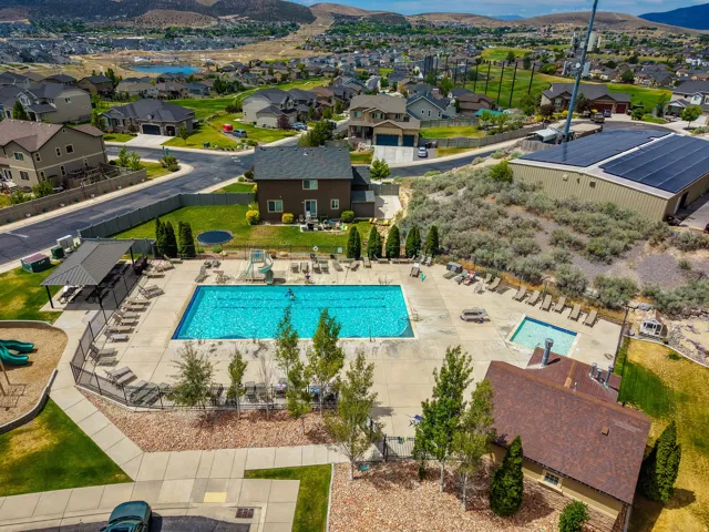 Community swimming pool with an integrated spa, surrounded by a concrete deck and lounge seating