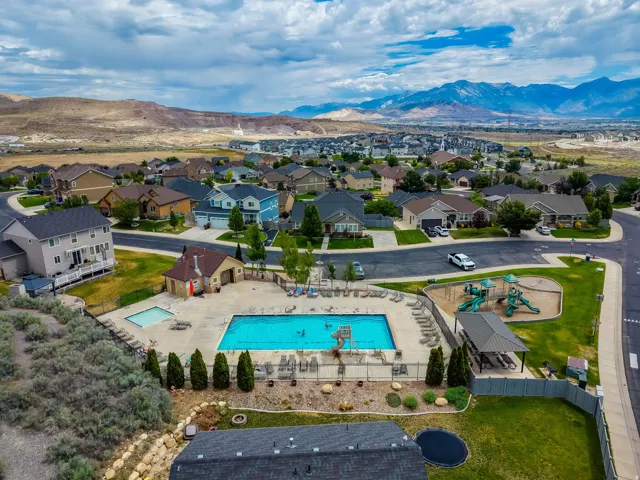 Aerial overview of a residential community featuring a large swimming pool with an adjacent smaller pool