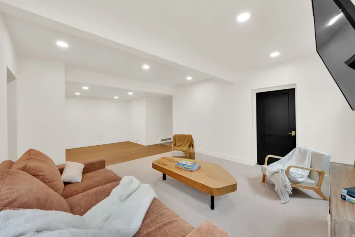 Spacious room featuring recessed lighting, a carpeted area, and a wood-finish flooring section