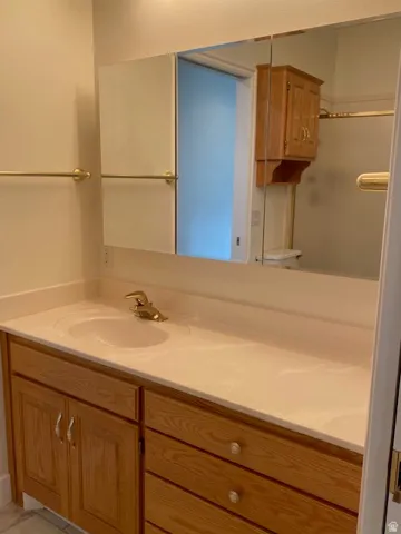 Wood-finish vanity with an integrated sink and gold-tone faucet