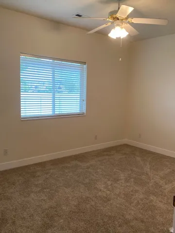 Wall-to-wall carpet flooring, window with blinds, and a ceiling fan with integrated lighting