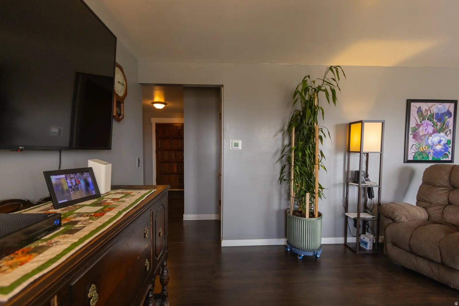 Spacious room featuring dark wood-finish flooring, light gray wall paint, and white trim