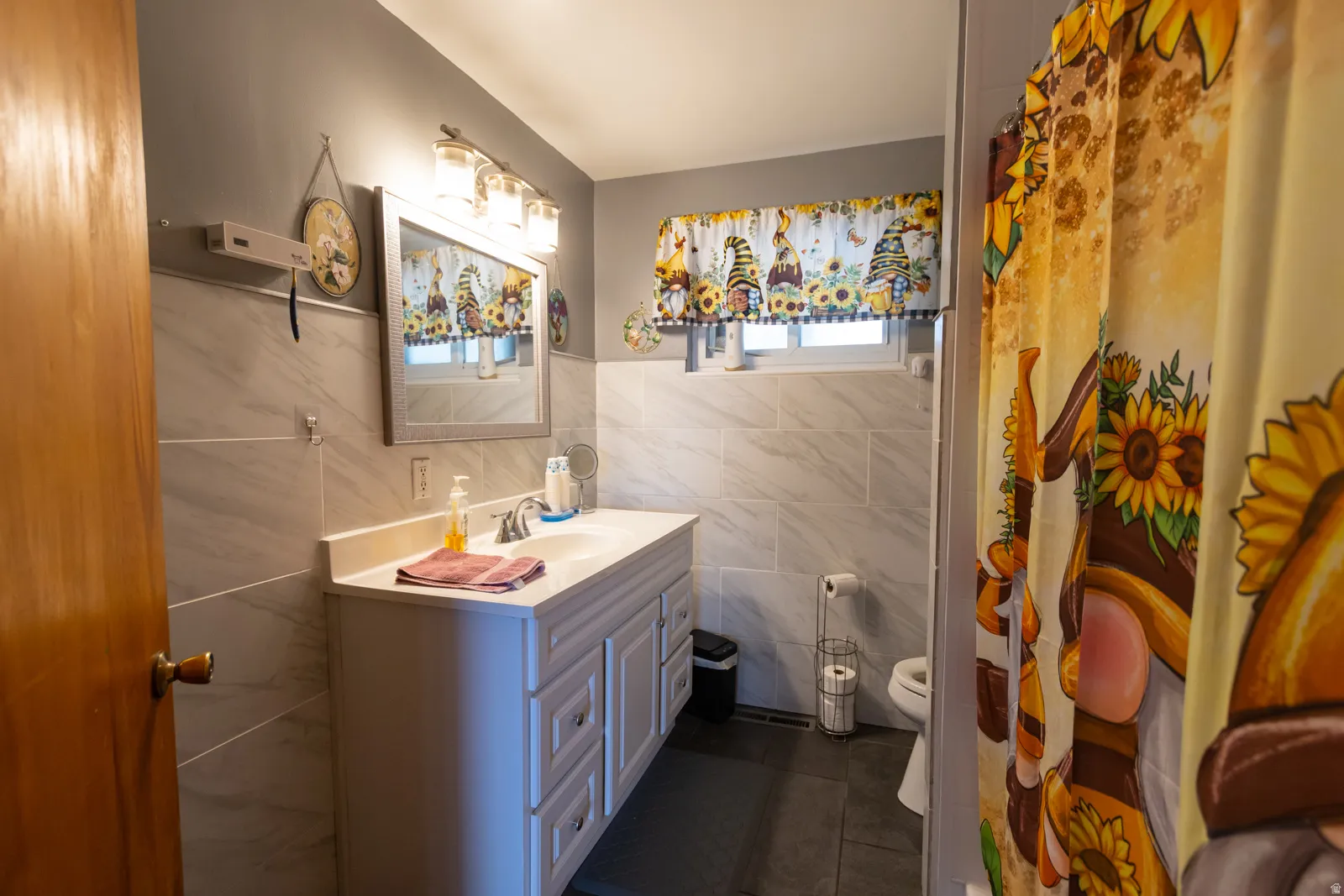 Bathroom featuring a white vanity with integrated sink, silver-tone faucet, and an overhead light fixture