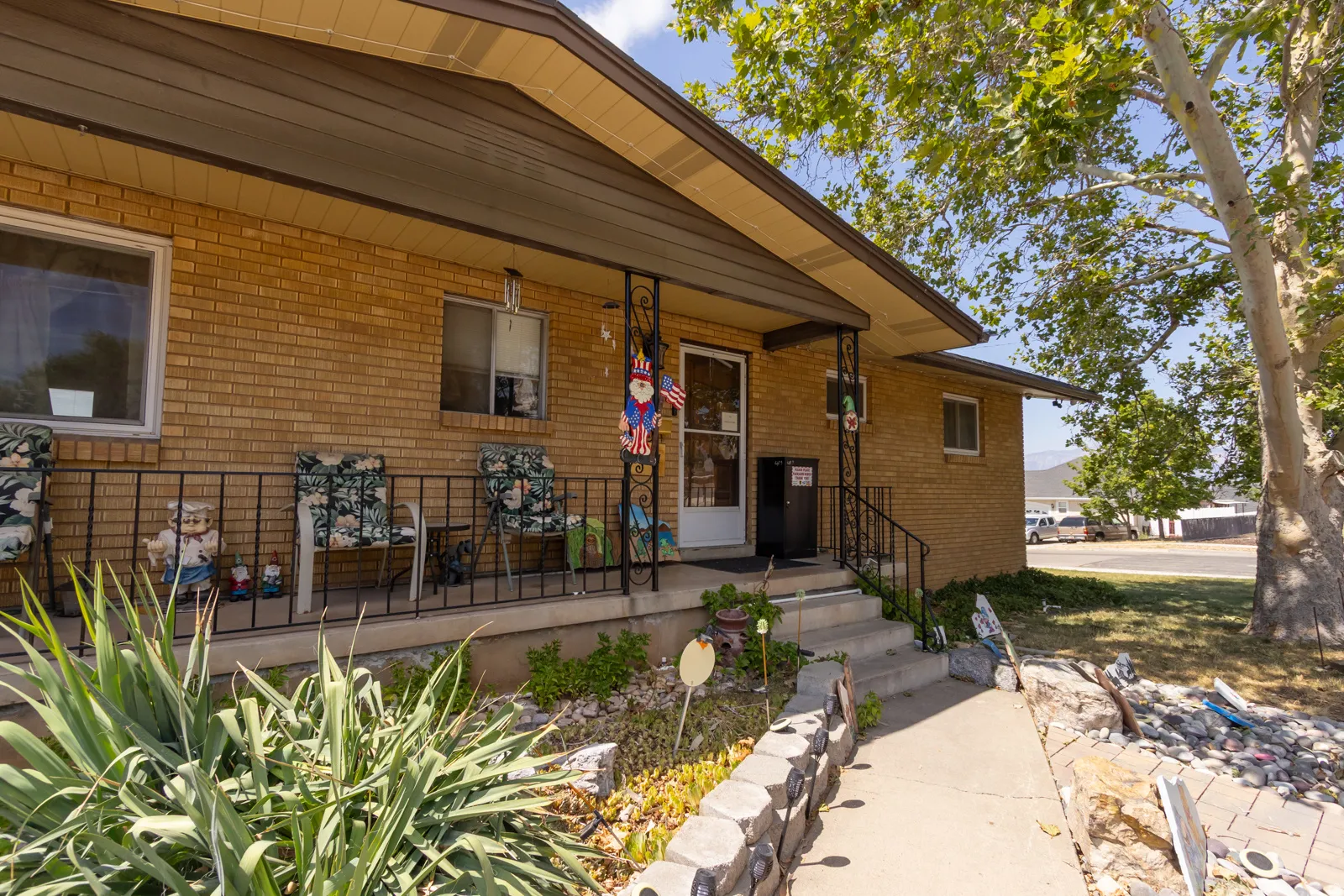 Brick exterior with a covered front porch featuring wrought iron railings