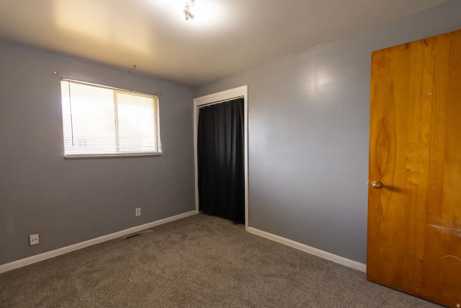 Bedroom featuring gray wall paint, light gray carpet flooring, and white baseboards