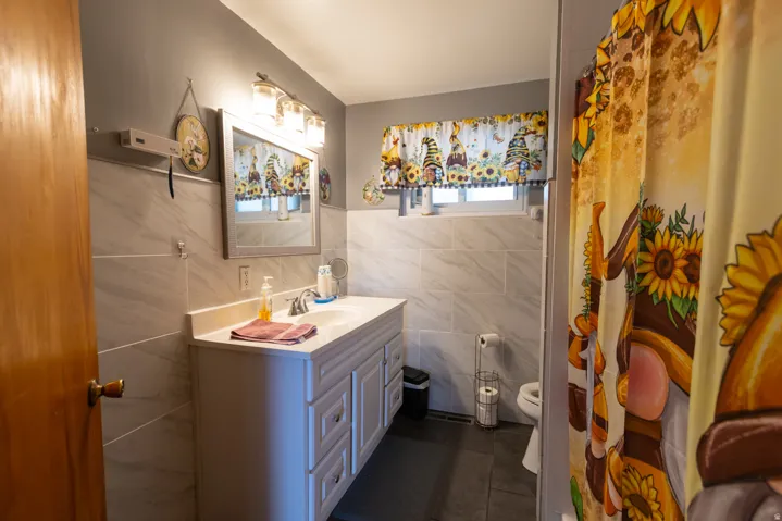 Bathroom featuring a white vanity with integrated sink, silver-tone faucet, and an overhead light fixture