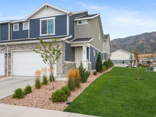 Multi-level townhome featuring a blue siding and stone veneer exterior