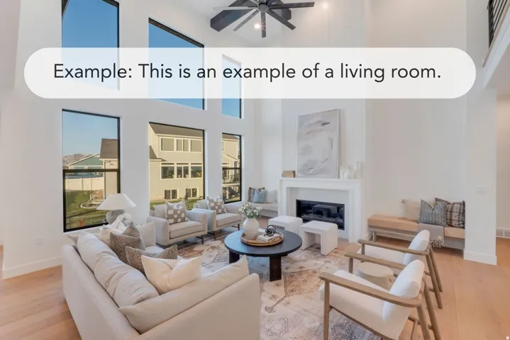 Two-story living area featuring a vaulted ceiling with a ceiling fan, abundant natural light through multiple windows, a modern fireplace with a white mantel, and light wood-finish flooring