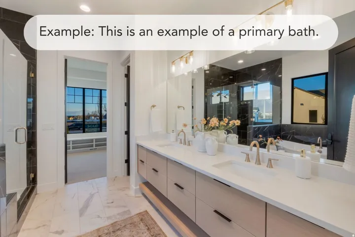Dual vanity with light wood-finish cabinetry, white countertops, and gold-tone fixtures