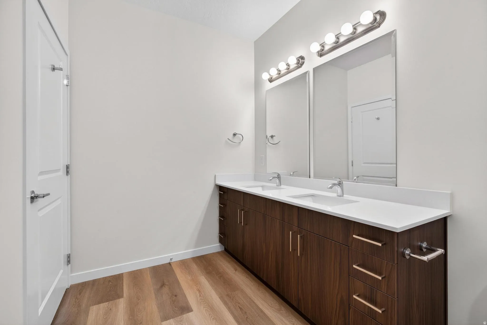 Dual vanity with wood-finish cabinetry and white countertops