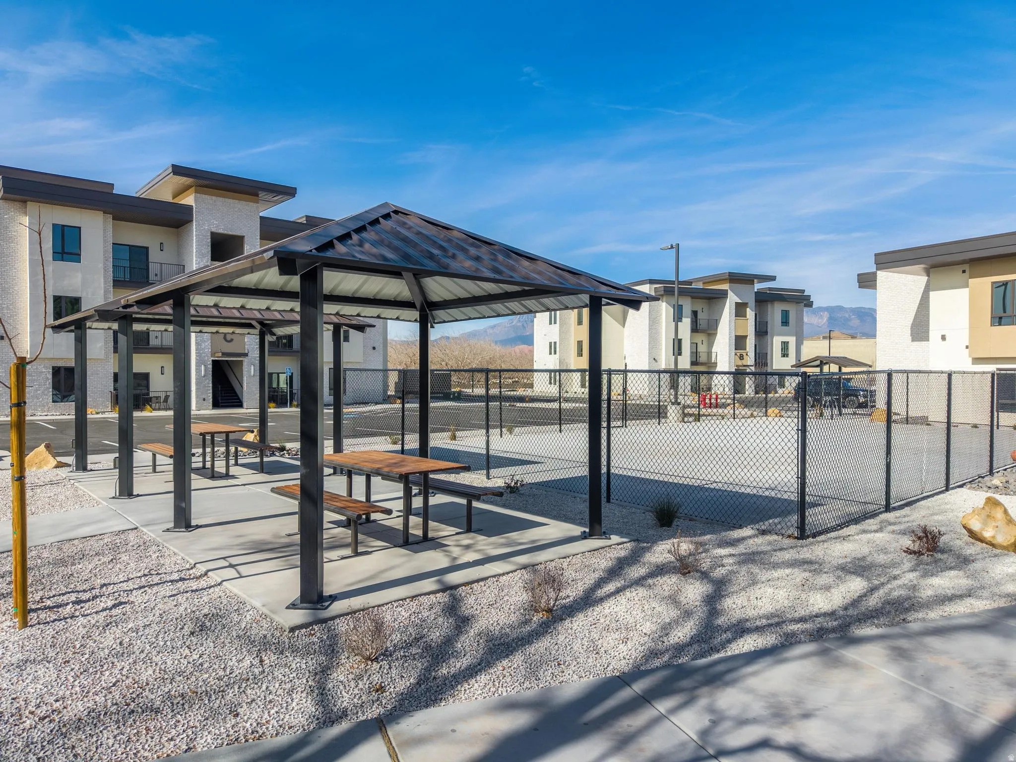 Outdoor covered picnic area featuring multiple tables with benches