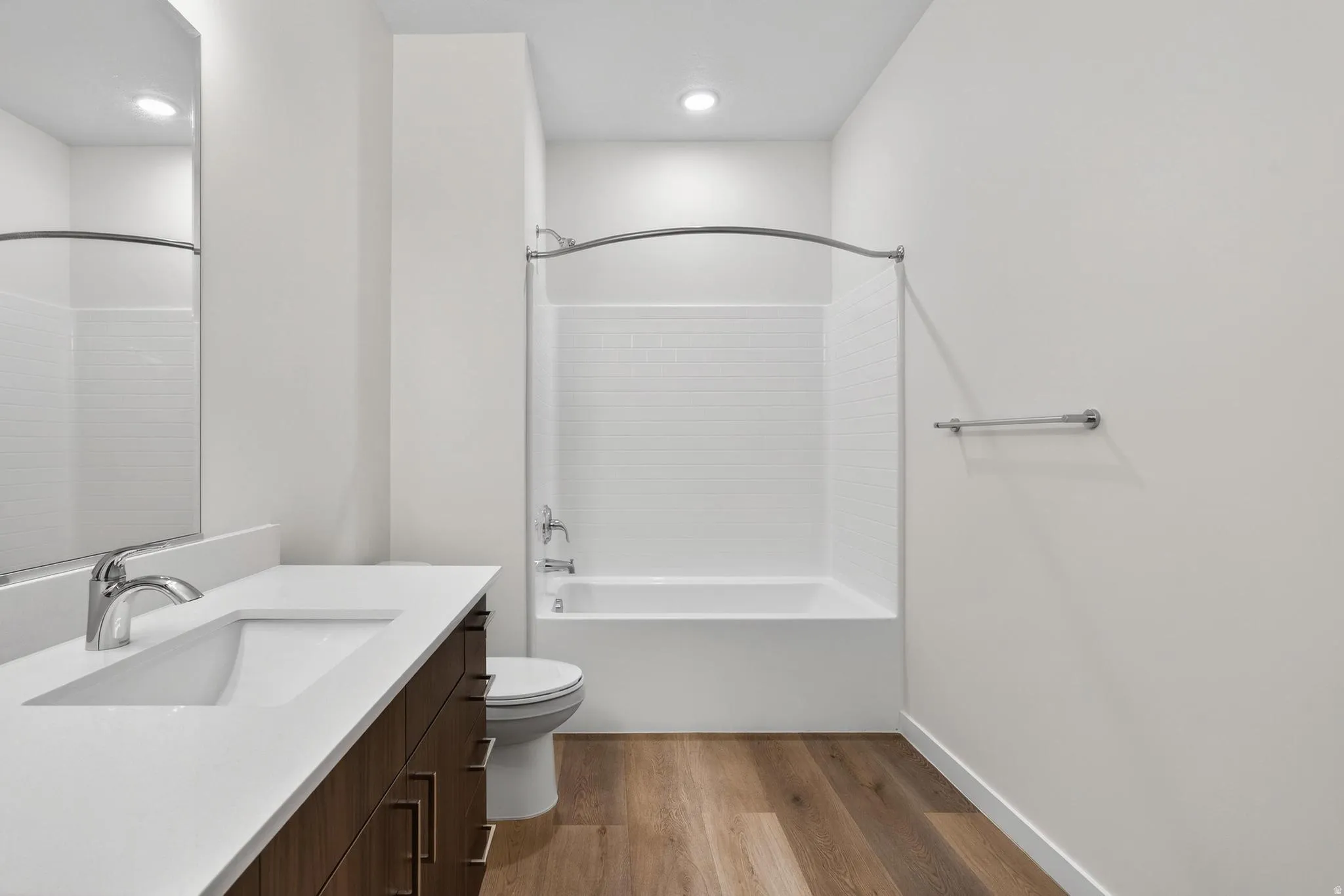 Bathroom featuring a full-sized tub with subway tile surround, chrome fixtures, and a curved shower rod