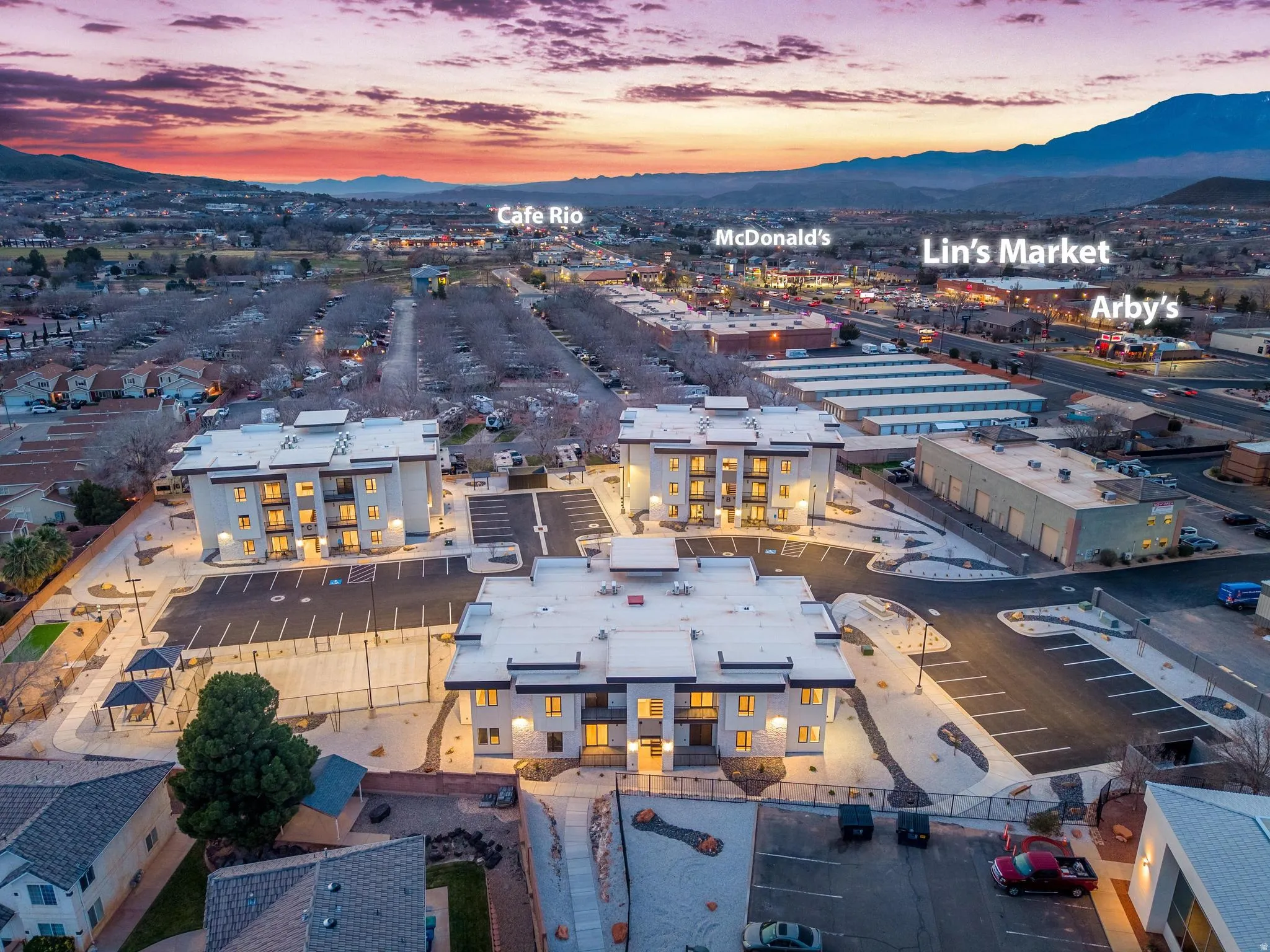 Modern multi-story buildings featuring balconies and exterior lighting