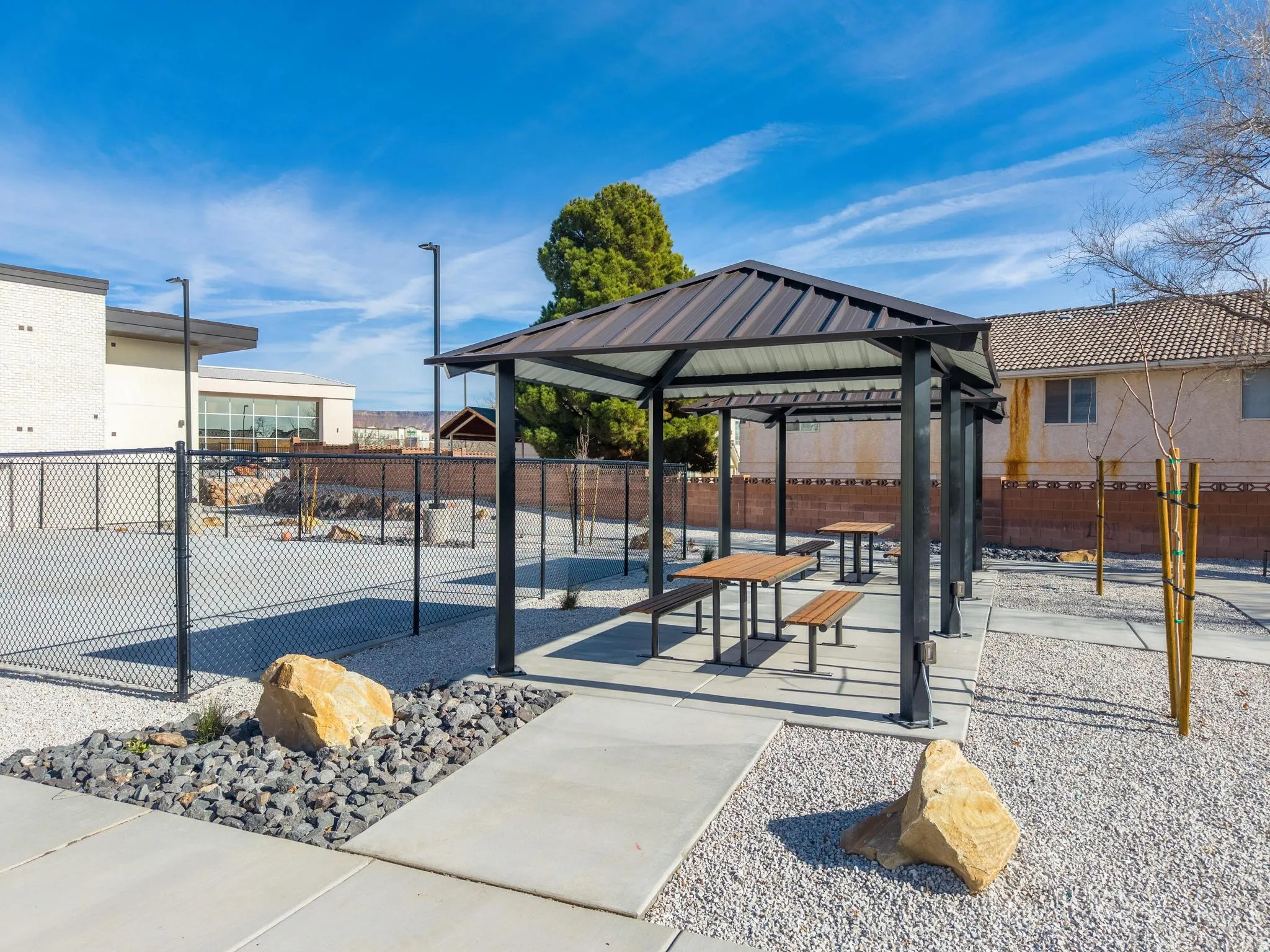 Outdoor covered patio featuring a metal roof, concrete slab, and built-in picnic tables