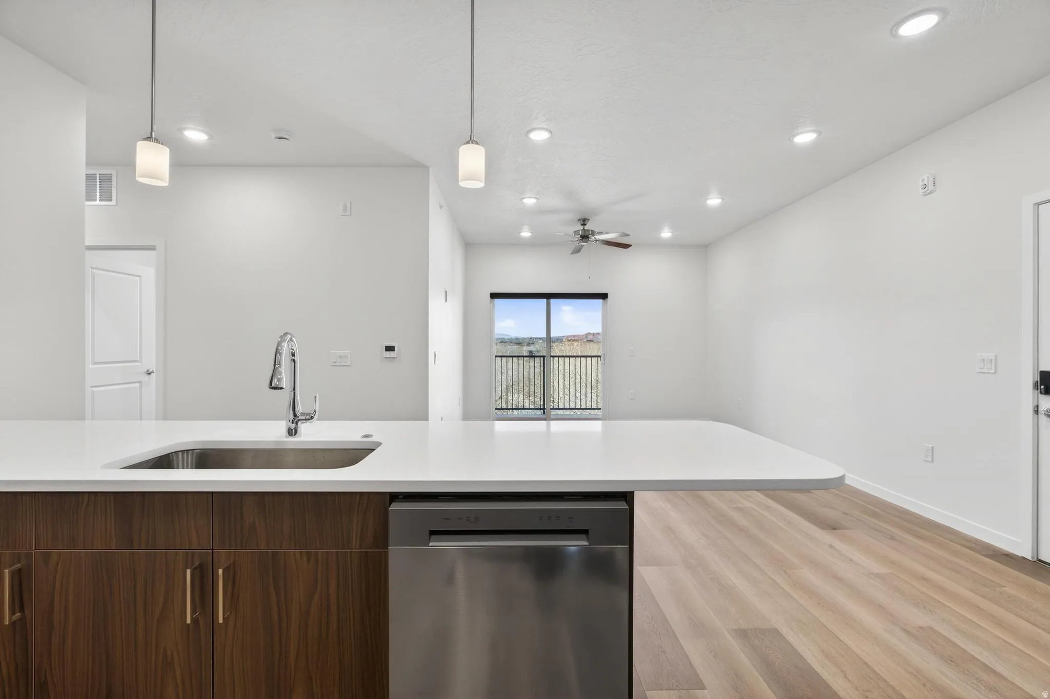 Spacious kitchen island with a stainless steel sink, contemporary faucet, and integrated dishwasher