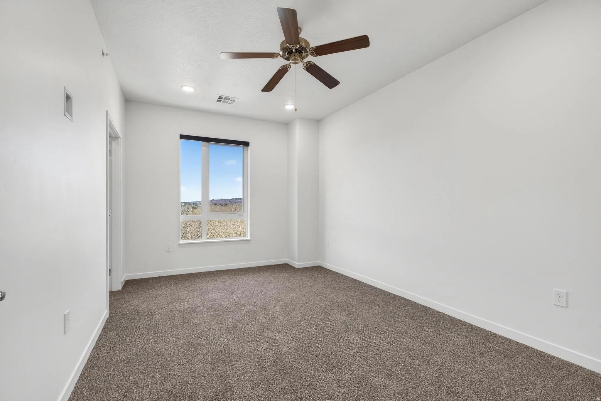 Carpeted room featuring a ceiling fan with integrated lighting, recessed lighting, a large window, and white walls