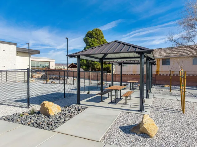 Outdoor covered patio featuring a metal roof, concrete slab, and built-in picnic tables
